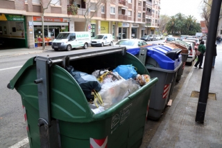 Imatge d&#039;una illa de contenidors del carrer de Cambrils de Reus, amb un contenidor de rebuig ple de brossa en primer terme