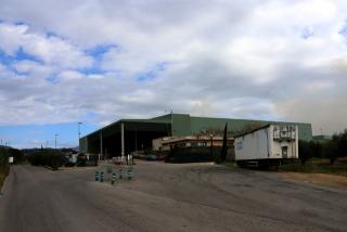 Entrada a la planta de compostatge de Secomsa a Botarell, amb la fumerada del nou incendi a la dreta de la imatge