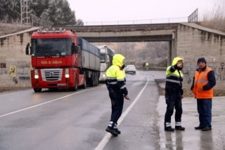 Dos agents dels Mossos d&#039;Esquadra enraonant amb un camioner a Montblanc, amb diversos camions desviats de l&#039;N-240 esperant per aparcar als afores de la ciutat