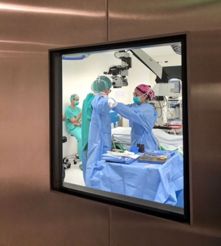 Imatge, a través del vidre d&#039;una porta, del personal mèdic de l&#039;Hospital Joan XXIII de Tarragona preparant-se per una intervenció quirúrgica