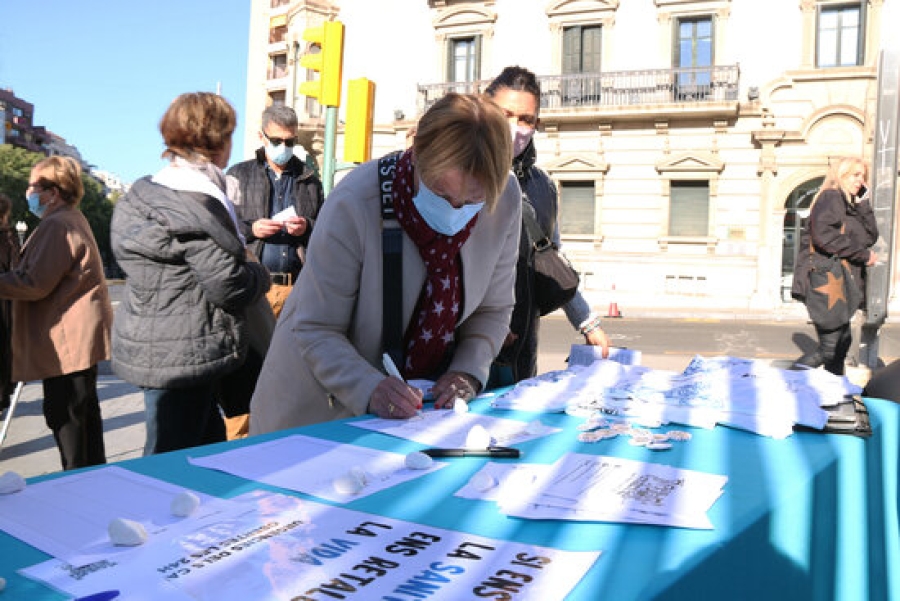 Imatge d&#039;una dona firmant les peticions fetes pels membres del grup de Treball en Defensa per la Sanitat Pública a Tarragona en les quals demanen una millor atenció primària