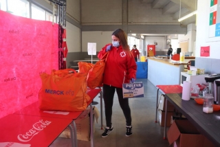 La tècnica de Creu Roja Tarragona, Marta Flores, descarrega el menjar que donen als sensesostre que han trobat feina perquè puguin subsistir fins que cobrin el primer sou, el 24 d&#039;abril del 2020 