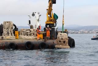 Dos operaris submergint un dels últims biòtops que vorejaran la primera muntanya marina construïda al Port de Torredembarra