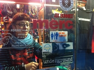 Una comerciant de Girona col·locant el distintiu de la campanya &#039;No puc esperar&#039; al vidre de l&#039;aparador