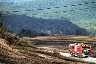 Imatge d&#039;un vehicle dels Bombers enmig d&#039;un paisatge cremat, a Bellprat, el 26 de juliol del 2021