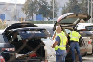 Els agents guardant als maleters dels vehicles motxilles i maletins a la sortida de la impremta