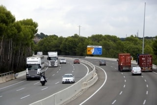 Imatge recent de camions circulant per l&#039;AP-7, a l&#039;alçada de Roda de Berà, amb un cartell indicatiu de diversos municipis de la Costa Daurada