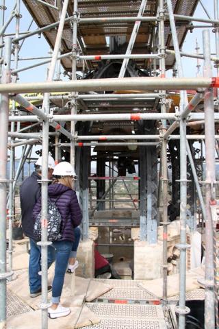 Dos dels responsables de les obres de restauració del campanar de Valls observant els treballs a la part superior de la torre