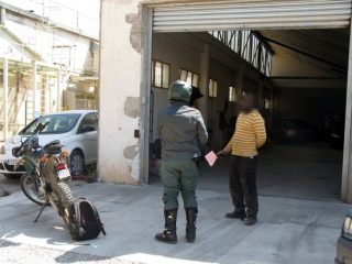 Imatge d&#039;un agent de la Guàrdia Civil i d&#039;un treballador del taller clandestí de Valls durant l&#039;actuació policial en aquesta nau