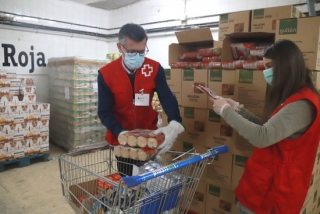 Dos voluntaris de Creu Roja Tarragona omplint el carro d&#039;aliments per una persona en situació de vulnerabilitat