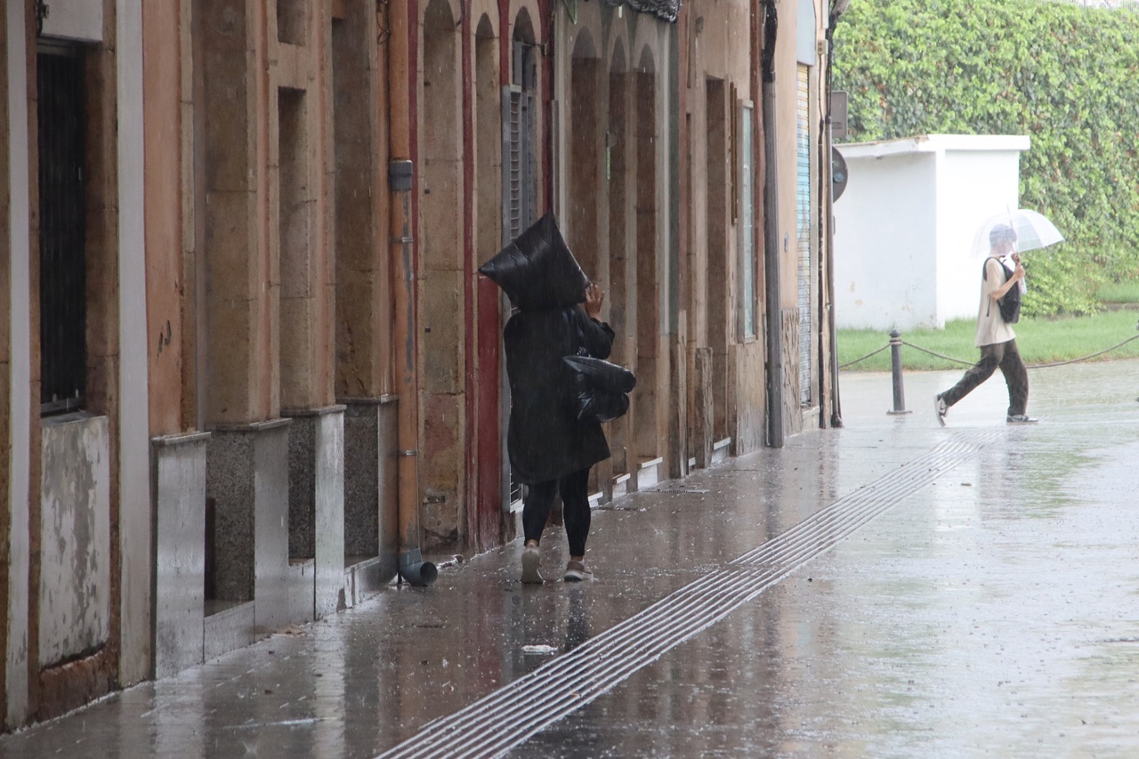 dona caminant pel serrallo amb pluja